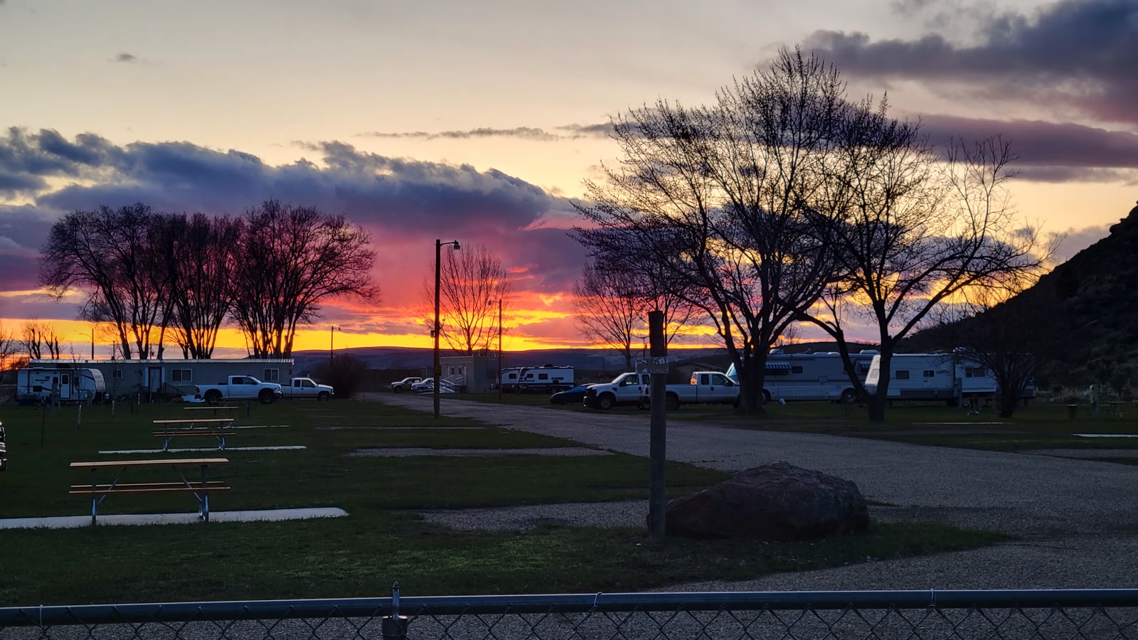 Blazing sunset sky over the RV sites and picnic tables at Sunny Ridge RV Park